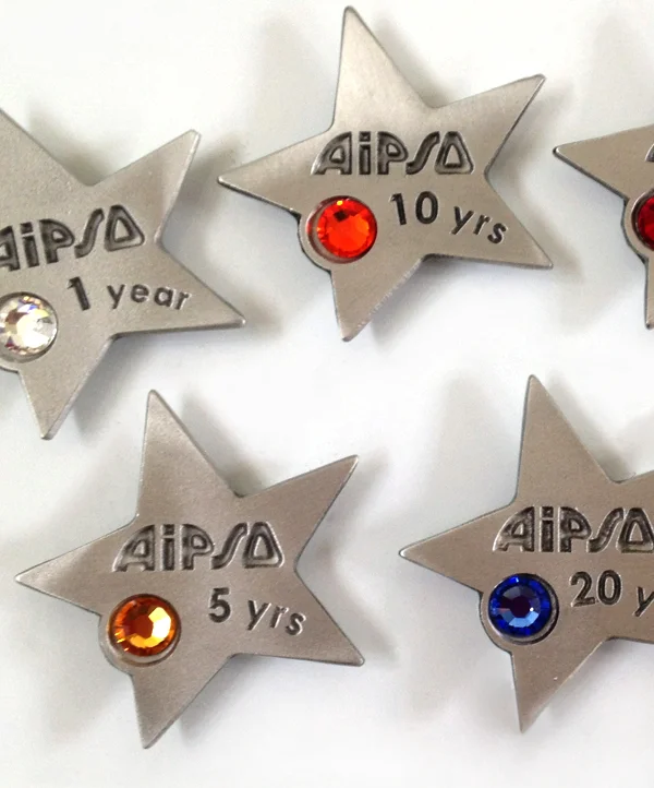 A collection of gleaming pewter stars, each engraved with years of service and adorned with a unique colored gemstone. 