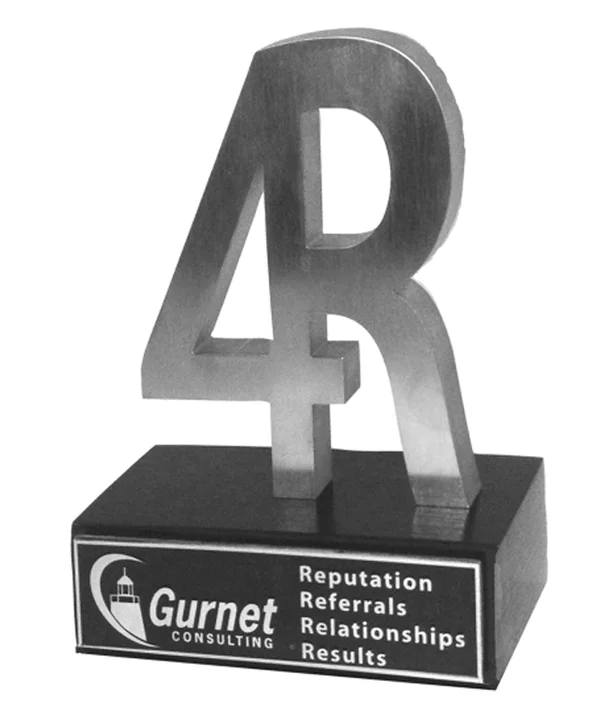 A polished stainless steel sculpture incorporating a fused 4 and R mounted on a black wooden stand.